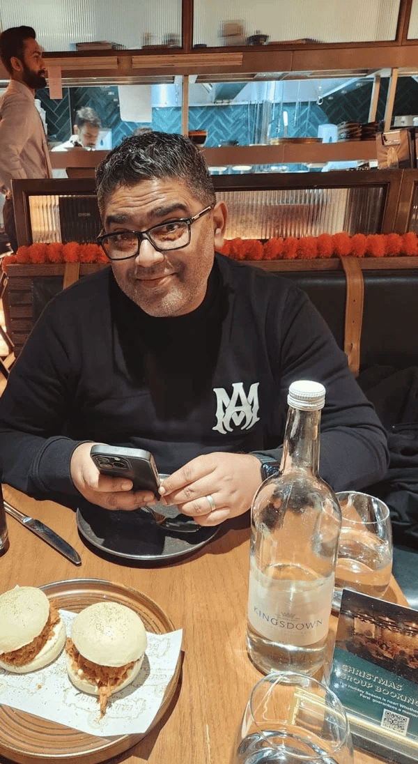 Ali, The Foodie Connoisseur UK, smiling at a restaurant table